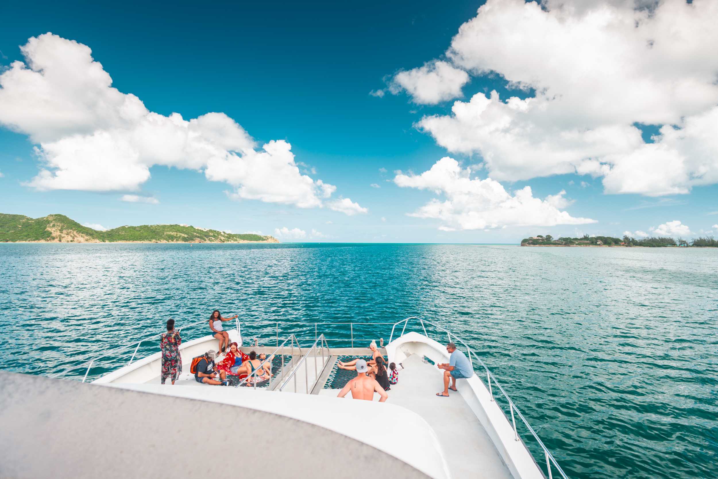 Guests viewing Antigua’s coastline from the bow of a tour boat