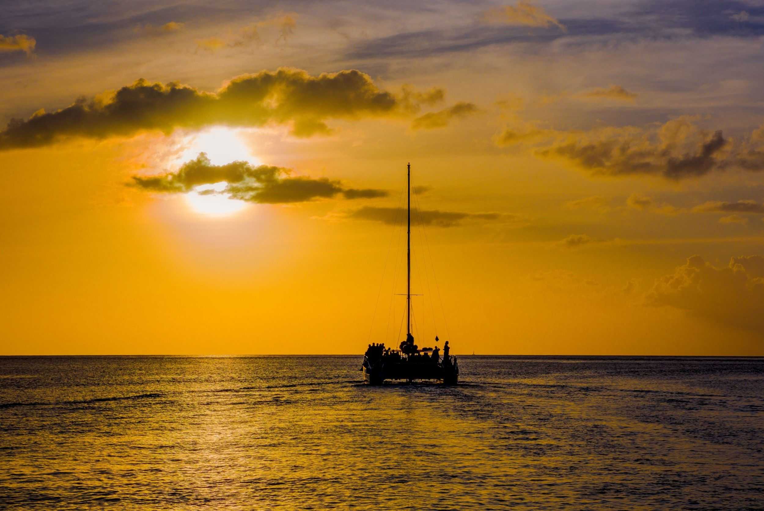 Catamaran silhouetted against a golden sunset off Antigua