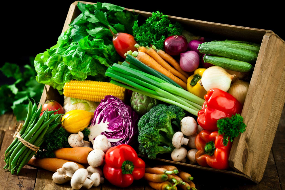 Crate filled with fresh herbs, peppers, and vegetables