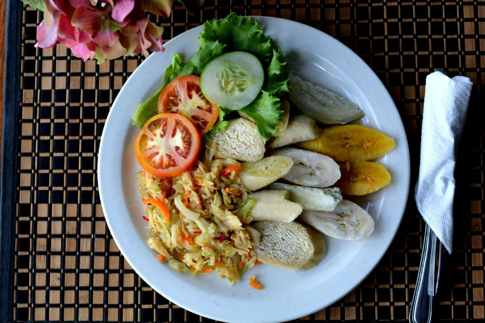 Plate of Caribbean food with vegetables, plantain, and ground provisions